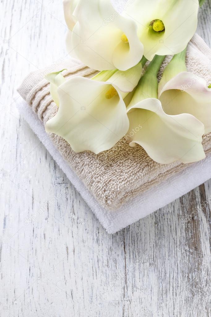 Towels and bouquet of white calla flowers