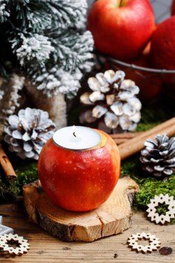 Kadın, elma, mum ve köknar dallarıyla nasıl Noel süsü yapılacağını gösteriyor. Adım adım, öğretici.