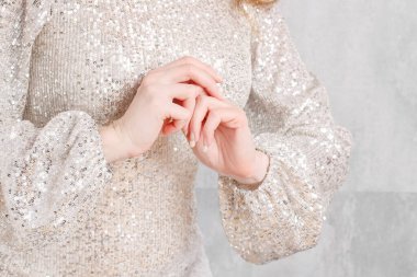 Gümüş pullu elbise giyen güzel elleri olan bir kadın. Parti zamanı.