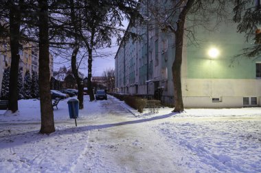 NOWY TARG, POLAND - HAZİRAN 04, 2025: kışın alacakaranlıkta sosyalist apartman bloklarının manzarası. Turistler için tatil yeri