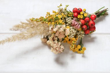 İşteki çiçekçi: kadın, yaz sonu çiçekleri ve bitkilerle nasıl buket yapılacağını gösteriyor. Adım adım, öğretici.