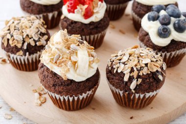 Taze meyveler ve yulaf ezmesi gevreği ile süslenmiş Muffins. Sağlıklı atıştırmalık. Parti tatlısı