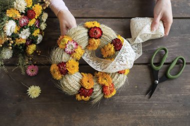Kadın helezonik braketatum ile nasıl çelenk yapılacağını gösteriyor. Sonsuz çiçekler. Adım adım, öğretici.