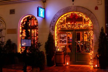 KRAKOW, POLAND - 28 HAZİRAN 2025: Parlak Noel ışıklarıyla süslenmiş sevimli mağaza vitrinleri. Turistler için tatil yeri