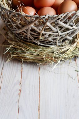 Saman üstünde tavuk yumurtası olan büyük bir sepet. Şenlik Dekoru