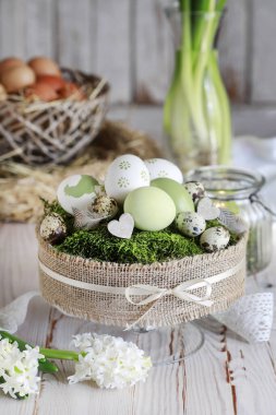 Klasik Paskalya masa dekorasyonu ve yosun üzerine boyanmış yumurtalar. Şenlikli parti dekorasyonu