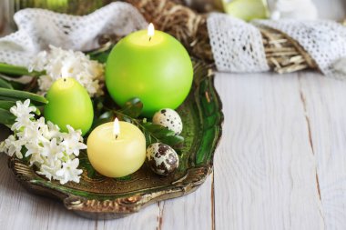 Mumlar, buxular, sümbül çiçekleri ve bıldırcın yumurtalarıyla Paskalya sofrası süslemesi. Şenlikli parti dekorasyonu