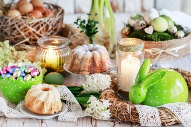 Yemek ve çiçeklerle dolu Paskalya masası. Kartpostal motifi. Şenlikli parti dekorasyonu