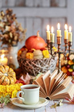 Masadaki sıcak çay, arka plandaki güzel sonbahar dekorasyonlarına karşı. Şenlikli parti dekorasyonu