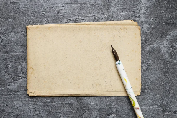 Folha de papel vintage e caneta-tinteiro sobre fundo cinza — Fotografia de Stock