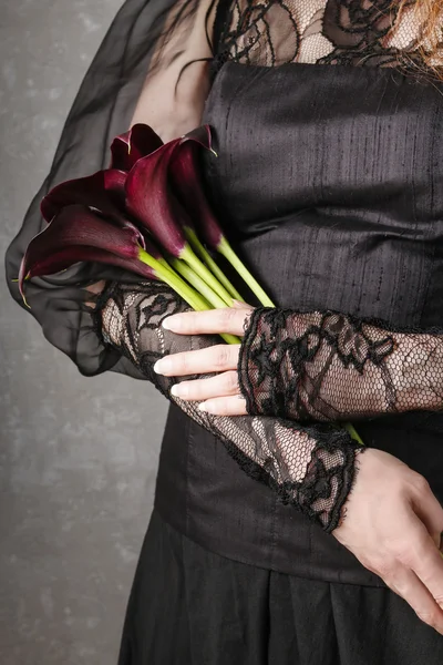 Mujer sosteniendo ramo de flores de cala negro (Zantedeschia ) — Foto de Stock