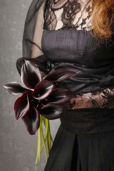 Femme tenant bouquet de fleurs de calla noires (Zantedeschia ) — Photo