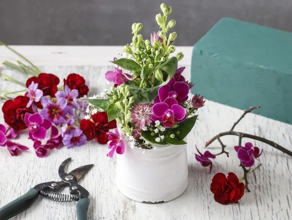 Květinářství pracoviště: aranžmá s květy orchidejí a gy — Stock fotografie