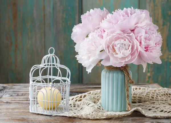 Bouquet of pink peonies and vintage birdcage with candle — Stock Photo, Image