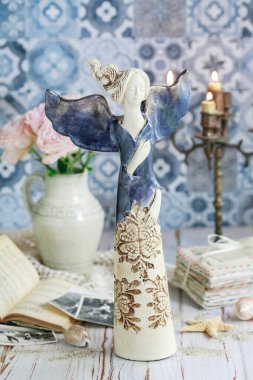 Masada mavi melek heykelciği olan bir kartpostal motifi. Grafiksel kaynaklar