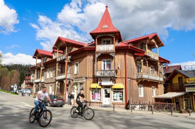 SZCZAWNICA, POLAND - 19 Nisan 2025: Tatil köyünün ana caddesindeki eski ahşap villa. Turistler için tatil yeri