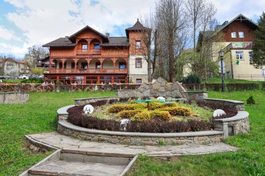 SZCZAWNICA, POLAND - 19 Nisan 2025: Tatil köyündeki parkın yanındaki eski ahşap villa. Turistler için tatil yeri