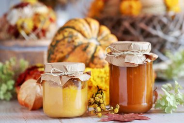 Masanın üzerinde balkabağı reçelleri olan cam kavanozlar. Sağlıklı yemekler, parti dekorasyonu.