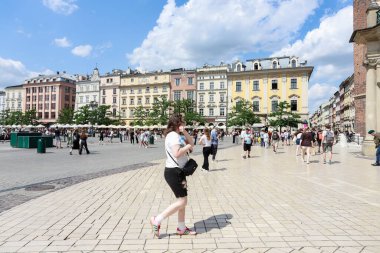 KRAKOW, POLAND - 24 Haziran 2025: Polonya 'nın Krakow kentindeki Ana Pazar Meydanı' ndaki (Rynek) eski apartmanlar. Turistler için tatil yeri