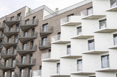 Pencere ve balkonların tekrar eden bir şekli, birbirine bağlı beyaz görsel bir yapı oluşturuyor. Grafiksel kaynaklar