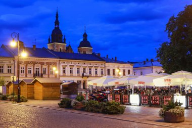 NOWY SACZ, POLAND - 12 Temmuz 2025: Nowy Sacz 'deki ana pazar meydanının etrafında gün batımında kaldırımlı caddeler. Turistler için tatil yeri