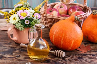 Masanın üzerinde bir şişe bal ve olgun balkabağı var. Sağlıklı yemek.