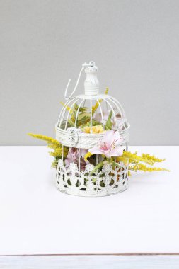 Çiçek aranjmanı gül, alstromerya ve eski bir kuş kafesinin içinde solidago çiçekleri. Adım adım, özel ders. Parti dekoru