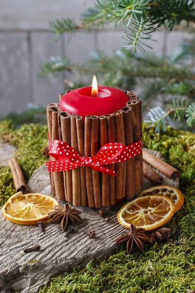 Bougie décorée avec des bâtons de cannelle et des fruits secs autour — Photo