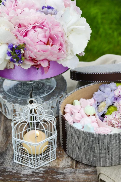 Table de fête de jardin : boîte de bonbons et bouquet de fleurs — Photo