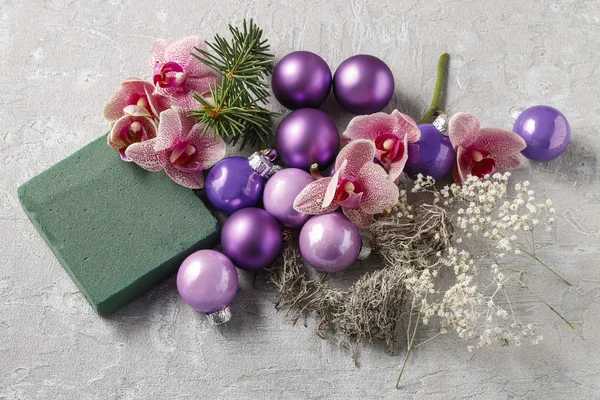 Mulher fazendo decorações de Natal com bolas violetas, abeto e ou — Fotografia de Stock