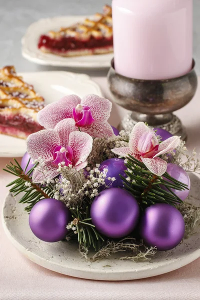 Mujer haciendo decoraciones navideñas con bolas violetas, abeto y / o — Foto de Stock