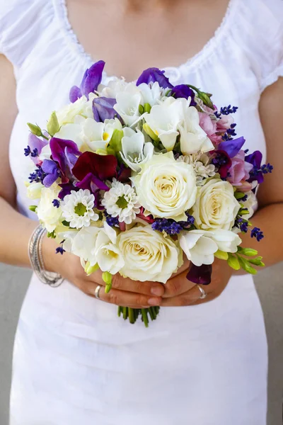 Braut hält Strauß mit weißen Rosen und lila Freesien — Stockfoto