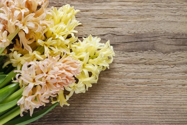 Gelbe und orangefarbene Hyazinthenblüten auf einem hölzernen Hintergrund — Stockfoto