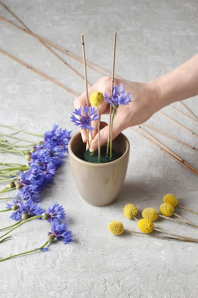 Florist at work: how to make floral arrangement with cornflowers — Stock Photo, Image