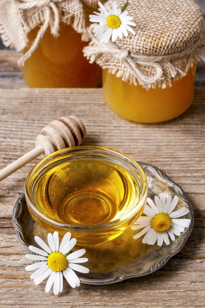 Bowl of honey and chamomile flowers — Stockfoto