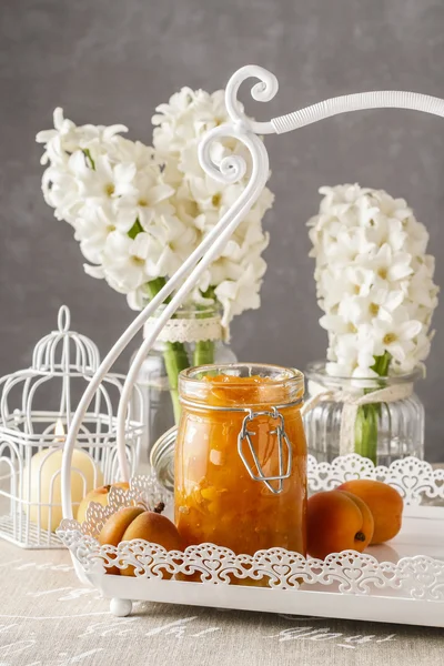 Glas mit Pfirsichmarmelade und Hyazinthenblüten im Hintergrund — Stockfoto