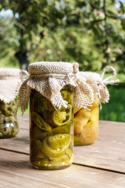 Pickled vegetables in preserving glass on wooden table — Stock Photo, Image