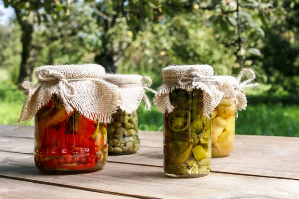 Pickled vegetables in preserving glass on wooden table — Stockfoto