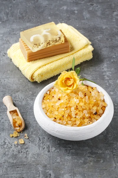 Bowl of yellow sea salt on gray stone background — Stockfoto