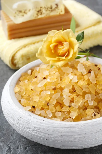 Bowl of yellow sea salt on gray stone background — Stockfoto