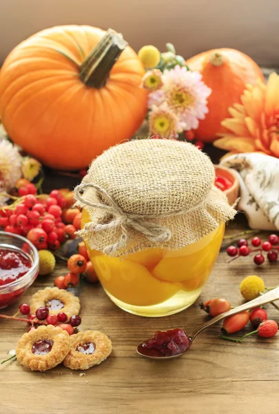 Tarro de melocotones en escabeche y hermosas flores y plantas de otoño —  Fotos de Stock