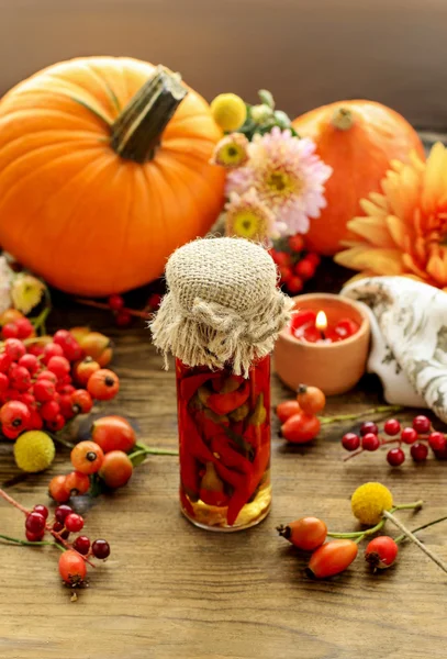 Tarro de pimientos rojos en escabeche y hermosas flores de otoño y plan —  Fotos de Stock