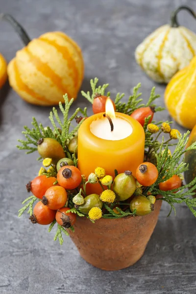 Beautiful table decoration with candle and autumn plants