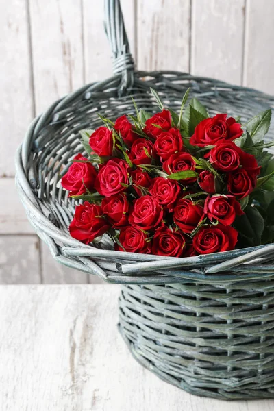 Bouquet of red roses in wicker basket — Stock Photo, Image