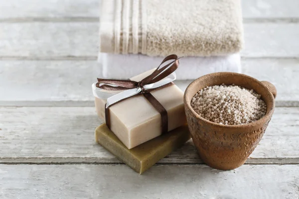 Ceramic pot with sea salt, two soft towels and bar of handmade s — Stock Photo, Image