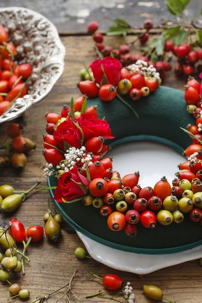 Étapes de fabrication de couronne de porte avec rose de la hanche, aubépine et rowan être — Photo