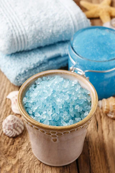 Чаша голубой морской соли и другая курортная косметика на деревенской древесине — стоковое фото