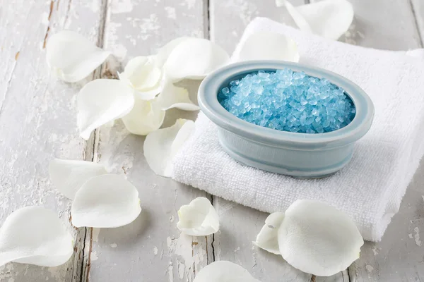 Kom met blauwe zee zout, wit roze bloemblaadjes rond — Stockfoto