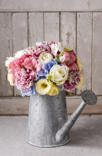 Bouquet of flowers in silver watering can