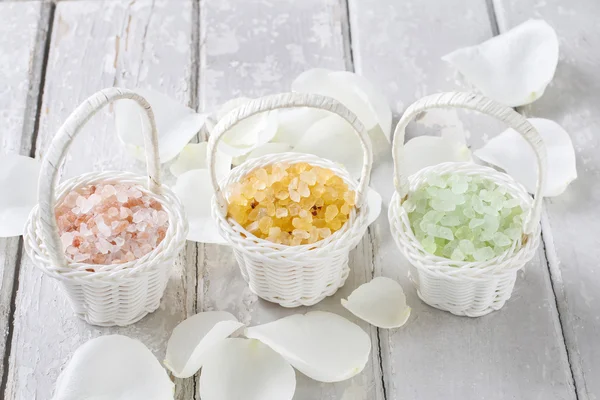 Sea salt in wicker baskets among white rose petals — Stock Photo, Image